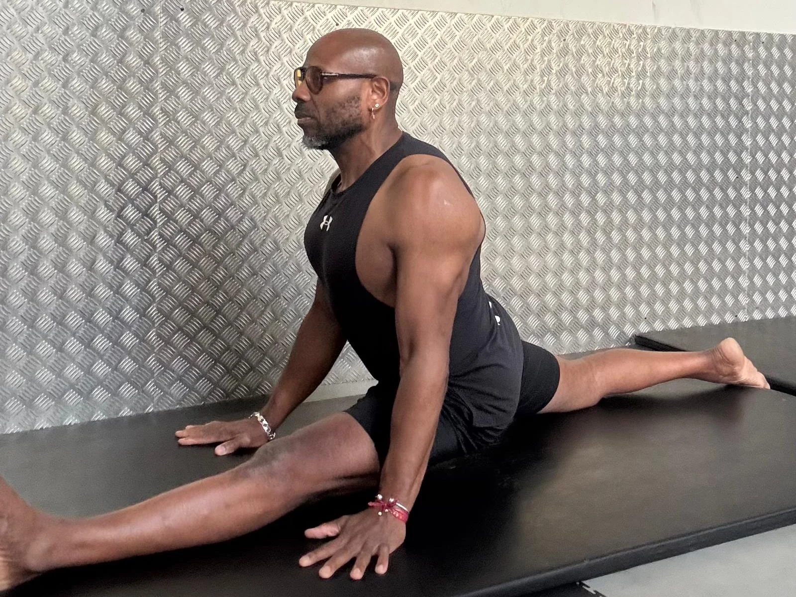 Chris practising a seated split pose at Fitness 4 Less