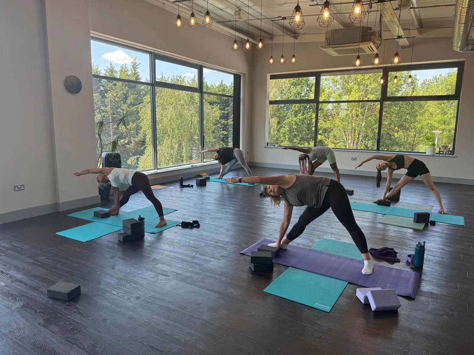 Students exploring a standing yoga pose in a bright room